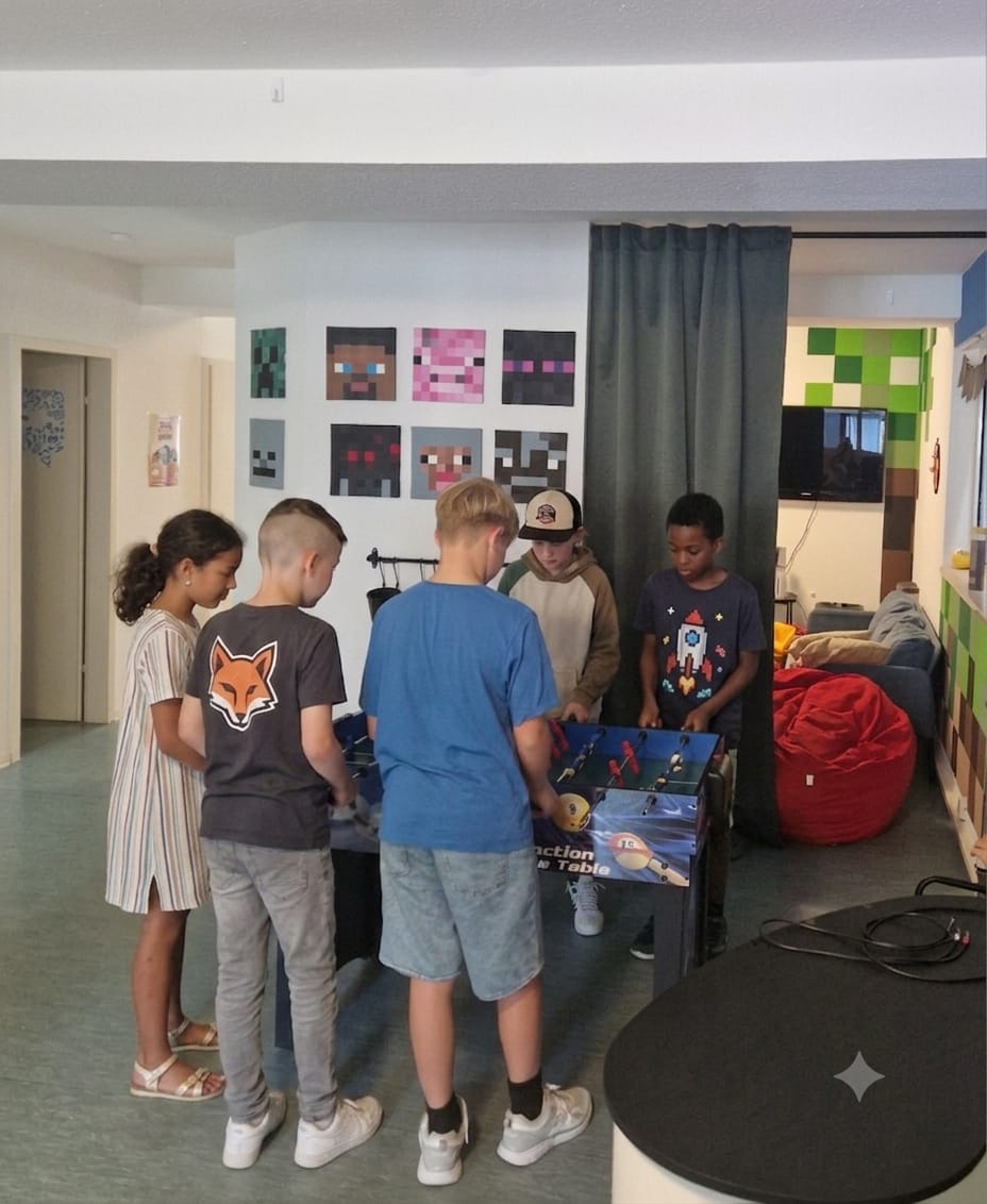 Kinder spielen in der Pause am Kickertisch (Kinder KI-anonymisiert)