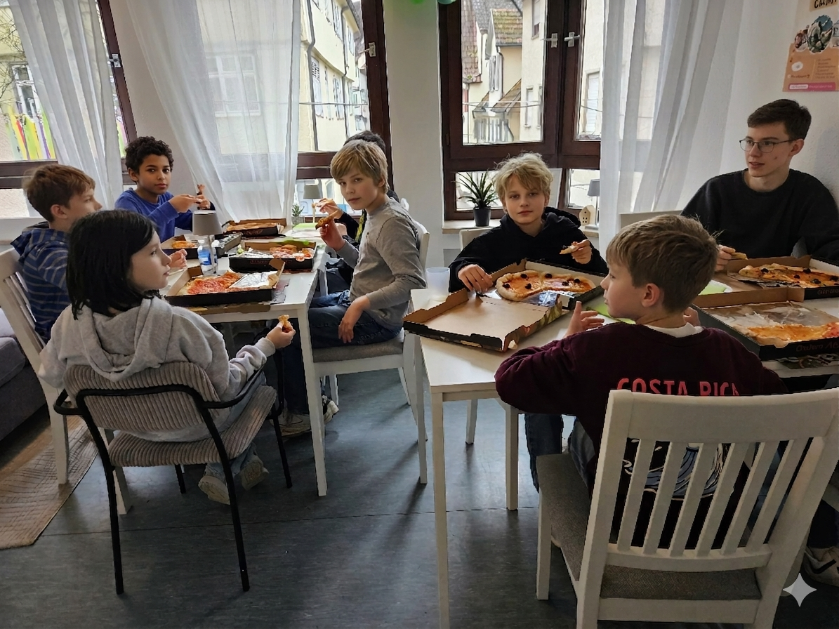 Kinder essen gemeinsam Pizza am langen Tisch (Kinder KI-anonymisiert)