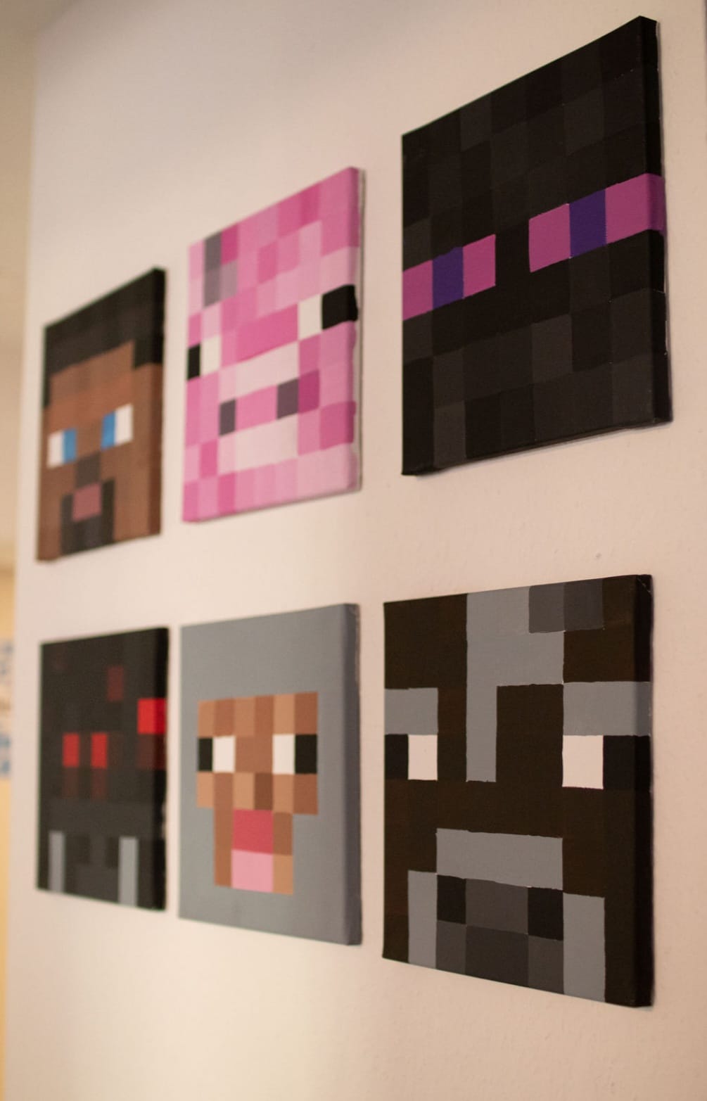 Selbstgemalte Minecraft-Köpfe auf Leinwänden an der Wand