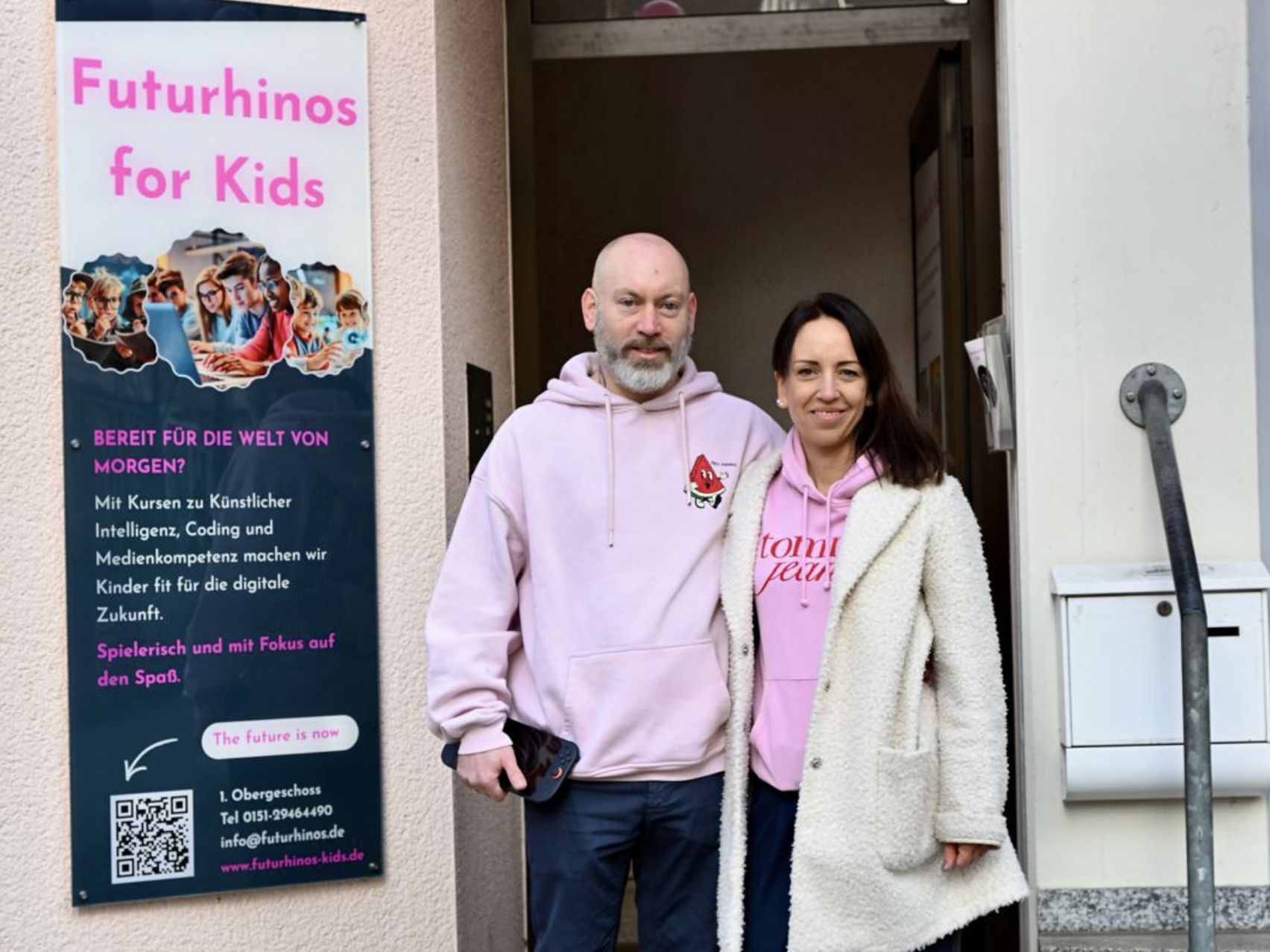 Astrid und René in pinken Hoodies vor dem Eingang neben dem Futurhinos-Banner