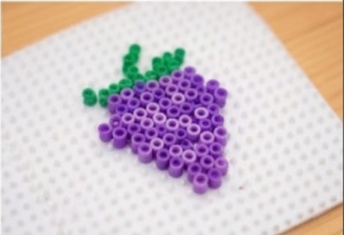 Fertige Pixel-Art-Traube aus lila und grünen Bügelperlen